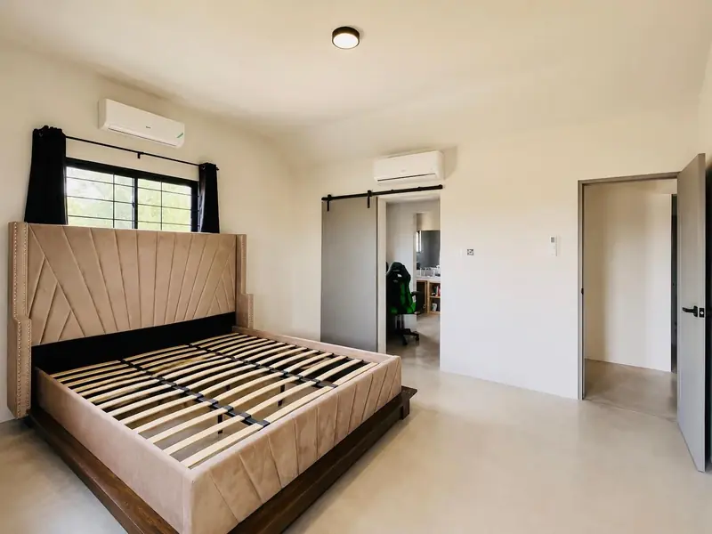 Bedroom with an upholstered bed frame and air conditioning