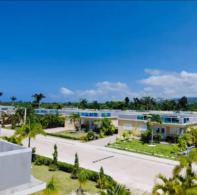 Marina Villas from above: villas, lawns and palm trees under a blue sky
