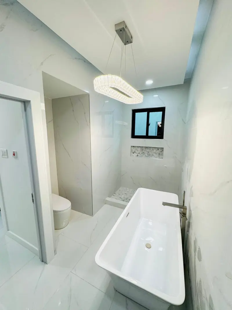 Primary bathroom with a free-standing soaking tub and marble-look tiles